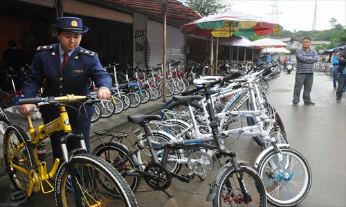 An official lines up fake BMW bicycles during an inspection in the Guangxi Zhuang Autonomous Region on Monday. The 96 bicycles were then confiscated for trademark violation. Photo: IC