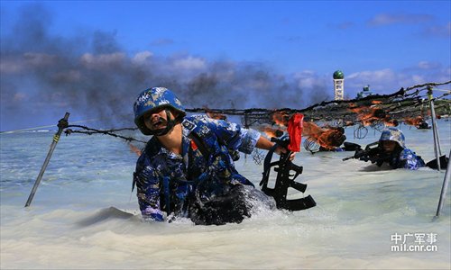 Soldiers crawl through water under flaming steel mesh as part of a military training competition held by the PLA on the Xisha Islands December 5. Photo: mil.cnr.cn