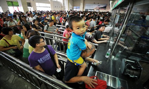 Passengers line up to get their tickets refunded at the Changsha railway station in Hunan Province on Sunday, hours after the torrential rain-triggered landslides collapsed a section of Beijing-Guangzhou railway and cut off the rail services in provinces along the line. Photo: CFP