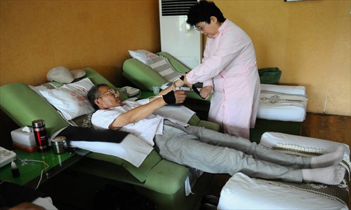 Wang Qinghua (left), a smoker from Liaocheng, Shandong Province, receives treatment at a private smoking cessation clinic on May 31. Photo: CFP