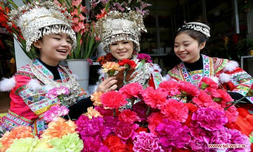 Young ladies of the Miao ethnic group select flowers for the coming Spring Festival in Rongshui County, south China's Guangxi Zhuang Autonomous Region, Feb. 8, 2013. The Spring Festival, the most important occasion for the family reunion for the Chinese people, falls on the first day of the first month of the traditional Chinese lunar calendar, or Feb. 10 this year. Photo: Xinhua
