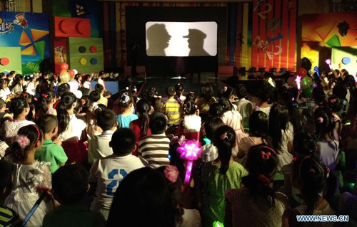 Little audiences watch a shadow show during a promoting activity of the Children's Channel of China Central Television (CCTV) in Beijing, capital of China, July 7, 2012. A series of new programs will be presented at the channel during the summer vacation. Photo: Xinhua