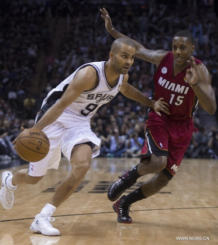 San Antonio Spurs Tony Parker (L) drives the ball during the Game 3 of the 2013 NBA Finals against Miami Heat in San Antonio, Texas, the United States, June 11, 2013. San Antonio Spurs won 113-77. (Xinhua/Yang Lei)