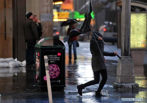 People walk at the Times Square in New York, the United States, on October 29, 2012. Hurricane Sandy, a massive storm described by forecasters as one of the largest ever that hit the United States, is making its way towards the population-dense East Coast. Michael Bloomberg, mayor of New York, has asked the public to stay at home when Sandy slams the city. Nearly 10,000 flights have been canceled for Monday and Tuesday by airlines bracing for Hurricane Sandy. Photo: Xinhua