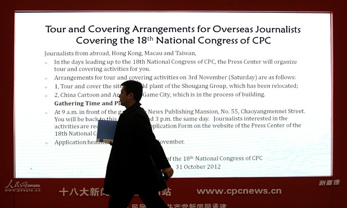 A man walks past an electronic billboard at the media center for the 18th CPC National Congress in Beijing on Thursday.  The CPC's Central Committee convened on Thursday for its final preparations for the 18th Party Congress, to be held in a week, to usher in leaders for the next decade. Photo: AFP