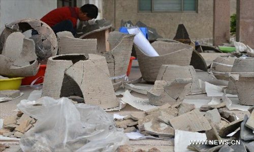 Photo taken on April 23, 2013 shows pottery pieces discovered at a newly discovered ancient workshop site in Zibo, east China's Shandong Province. A bronze mirror workshop, dating from some 2,000 years ago in China's Han Dynasty (202 B.C.-220 A.D.), was discovered in Zibo and believed to be the first of its kind discovered in China. Photo: Xinhua