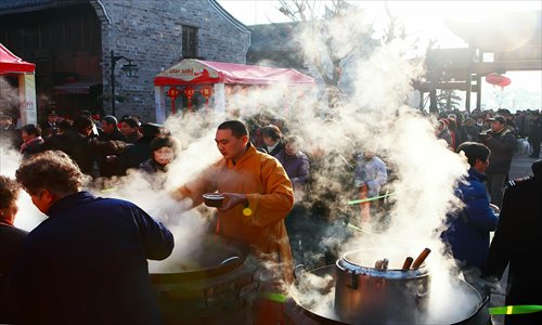 A monk hands out free Laba congee to residents at a temple in Ningbo, Zhejiang Province Saturday. Photo: CFP