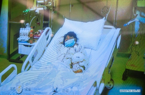 Photo taken on April 13, 2013 shows a screen showing a seven-year-old girl, who was infected with the H7N9 strain of bird flu, receiving medical treatment in the Beijing Ditan Hospital, during a press conference held by the hospital in Beijing, capital of China. This was the first such case in the Chinese capital. The child is in stable condition. Two people who have had close contact with the child have not shown any flu symptoms, and the girl's parents were engaged in live poultry trading in a township of Shunyi District in Beijing's northeastern suburbs. (Xinhua/Zhang Yu) 