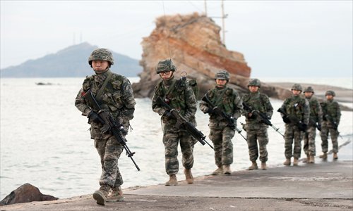 South Korean soldiers patrol on the South-controlled island of Yeonpyeong near the disputed waters of the Yellow Sea at dawn on Thursday. South Korea will this week carry out an intensive military drill to mark the anniversary of the shelling of the border island of Yeonpyeong by North Korea three years ago. Photo: AFP