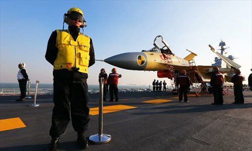 This undated photo shows staff members checking a carrier-borne J-15 fighter jet on China's first aircraft carrier, the Liaoning. China has successfully conducted flight landing on its first aircraft carrier, the Liaoning. After its delivery to the People's Liberation Army (PLA) Navy on Sept. 25, the aircraft carrier has undergone a series of sailing and technological tests, including the flight of the carrier-borne J-15. Capabilities of the carrier platform and the J-15 have been tested, meeting all requirements and achieving good compatibility, the PLA Navy said. Designed by and made in China, the J-15 is able to carry multi-type anti-ship, air-to-air and air-to-ground missiles, as well as precision-guided bombs. The J-15 has comprehensive capabilities comparable to those of the Russian Su-33 jet and the U.S. F-18, military experts estimated. Photo: Xinhua