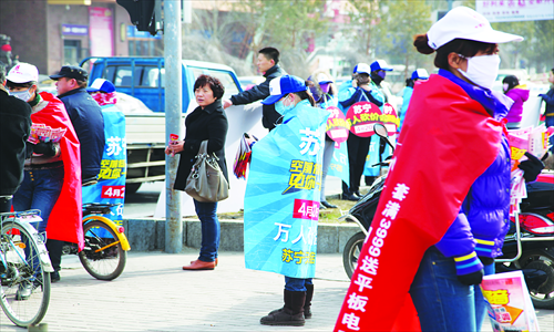 Marketers from Suning, Gome and Huasheng Group hand out flyers to pedestrians in Jilin, Jilin Province. As May Day approaches, many of China's appliance retailers are gearing up for holiday sales events. Photo: CFP 