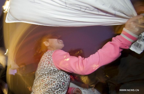 People participate in the pillow fight at the Nathan Phillips Square in Toronto, Canada, April 6, 2013. (Xinhua/Zou Zheng) 