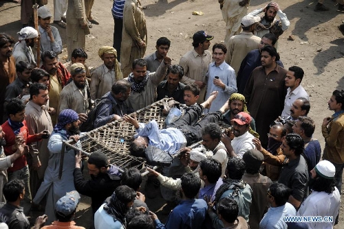 Pakistani demonstrators carry an injured man during a protest in a Christian neighborhood in Badami Bagh area of eastern Pakistan's Lahore on March 9, 2013. Hundreds of angry protestors on Saturday set ablaze more than 100 houses of Pakistani Christians over a blasphemy row in the eastern city of Lahore, local media reported. Over 3,000 Muslim protestors turned violent over derogatory remarks allegedly made by a young Christian against Prophet Mohammed in a Christian neighborhood in Badami Bagh area. (Xinhua Photo/Sajjad) 