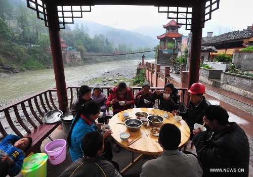 Villagers have dinner beside a river in quake-hit Yuxi Village of Lushan County, southwest China's Sichuan Province, April 23, 2013. A 7.0-magnitude jolted Lushan County on April 20. (Xinhua/Xiao Yijiu) 