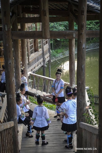 People chat in Dimen Dong minority village in Liping County of southwest China's Guizhou Province, June 20, 2013. Dimen is a Dong minority village with about 2,500 villagers. It is protected properly and all the villagers could enjoy their peaceful and quiet rural life as they did in the past over 700 years. (Xinhua/Ou Dongqu)