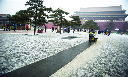 A cleaner clears a path through the snow in front of Duanmen, one of the main gates of the Forbidden City, Thursday. Photo: Li Hao/GT