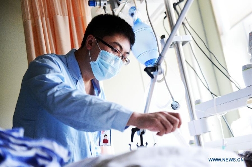 Li Weixing, a nurse of the 1st Affiliated Hospital of Harbin Medical University, takes care of a patient at the Intensive Care Unit in the hospital in Harbin, capital of northeast China's Heilongjiang Province, May 11, 2013. Male nurses in China are scarce, whose number accounts for merely one percentage of the total nurses in the country. Many people attribute the scarcity to society's view point that nursing is a women's job. Women are seen as more careful and patient than men, but, in general, male nurses are physically stronger or more energetic than women. They are particularly needed in Intensive Care Units, emergency departments, psychiatric hospitals and so on. (Xinhua/Wang Kai)