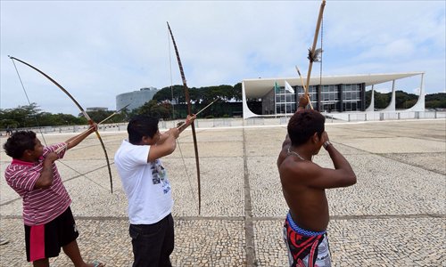 Indigenous Brazilians from different ethnic groups aim their bows at Planalto Palace, the official workplace of Brazil's president during a protest in Brasilia on Tuesday. The protest is aimed at attracting  attention on the Amazonia situation ahead of the FIFA World Cup, which starts on June 12. 