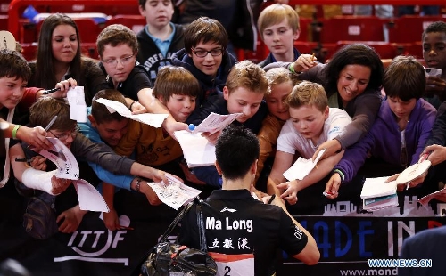 Ma Long of China signs for supporters after the semifinal of men's singles against his teammate Wang Hao at the 2013 World Table Tennis Championships in Paris, France on May 19, 2013. Ma lost 2-4. (Xinhua/Wang Lili) 