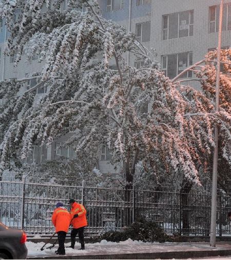 Sanitation workers clear snow in Changchun, capital of Northeast China's Jilin Province, October 22, 2012. Most parts of Jilin witnessed snowfall on Monday. Photo: Xinhua