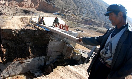 A villager points to a collapsed dam in Yuzhong county, Gansu Province. The collapse caused widespread flooding, cutting off roads and forcing 200 people to go without drinking water. Photo: CFP