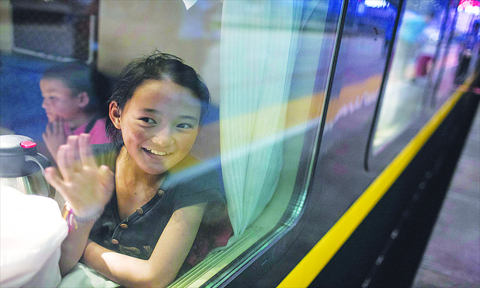 Lhamo Choezin, 12, waves goodbye from the Beijing-Lhasa train on Sunday evening. Photo: Li Hao/GT