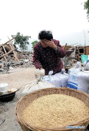 Zhang Zhizhen, a 83-year-old villager, cries after seeing her grain transferred out of the ruins of her house by militiamen and villagers at the quake-hit Lushan County, southwest China's Sichuan Province, April 21, 2013. A 7.0-magnitude earthquake jolted Lushan County on April 20, leaving at least 192 people dead and 23 missing. More than 11,000 people were injured. (Xinhua/He Junchang) 