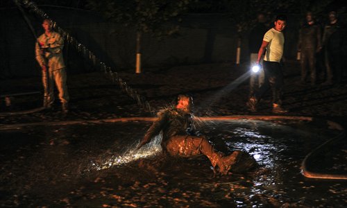 The last trainee to finish the crawl is punished in the mud. Photo: Yang Yifan/Tencent News