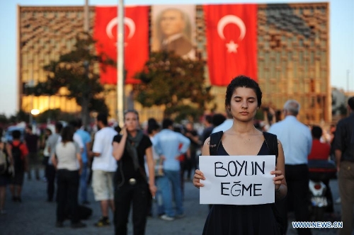 A protestor stands silently in front of Ataturk culture centre near the Taksim Square in Istanbul, Turkey, on June 18, 2013. Hundreds of people stood silently from morning to evening on Tuesday here to protest against the government. Nationwide protests began when an environmentalists' rally aiming to preserve Gezi Park adjacent to Taksim Square in Istanbul met fierce police crackdown, which triggered a wave of fiery opposition against the government's policies. (Xinhua/Lu Zhe) 