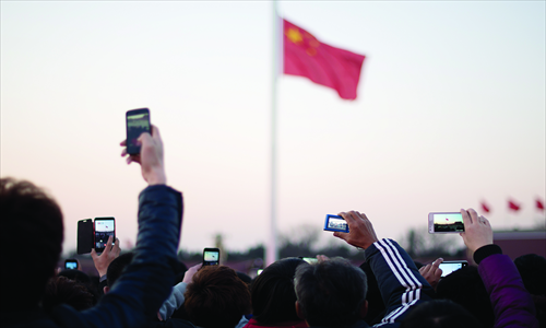 Tourists take photos during the daily flag-lowering ceremony at Tiananmen Square on Monday. The first session of the 12th National People's Congress starts on Tuesday, which will produce the country's top government leadership. Photo: AFP