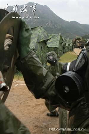 A shore-based mobile anti-ship-missile regiment under the South China Sea Fleet of the Navy of the Chinese People’s Liberation Army (PLA) organized a NBC (nuclear, biological and chemical) defense drill against actual-combat background on April 7, 2013. The picture shows the officers and men of the regiment are carrying out decontamination and detection of chemical agents in the infected “toxic” areas. (China Military Online/Sheng Yuehua, Zhao Changhong and Zheng Can)