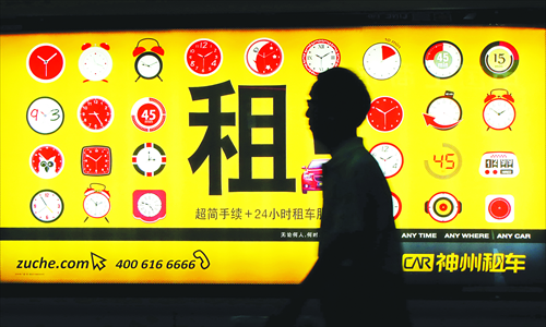 A man walks past a car rental advertisement in Shanghai. Photo: CFP