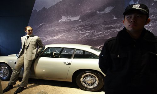 A security guard stands in front of one of the famous James Bond movie cars at the exhibition Designing 007: Fifty Years of Bond Style at the Minsheng Art Museum Thursday. The exhibition features the designs of costumes, props and gadgets from 23 Bond movies. It will last for three months. Photo: Xinhua