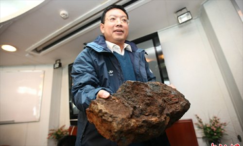 A researcher shows the newly discovered undersea rock. Photo:Chinanews.com
