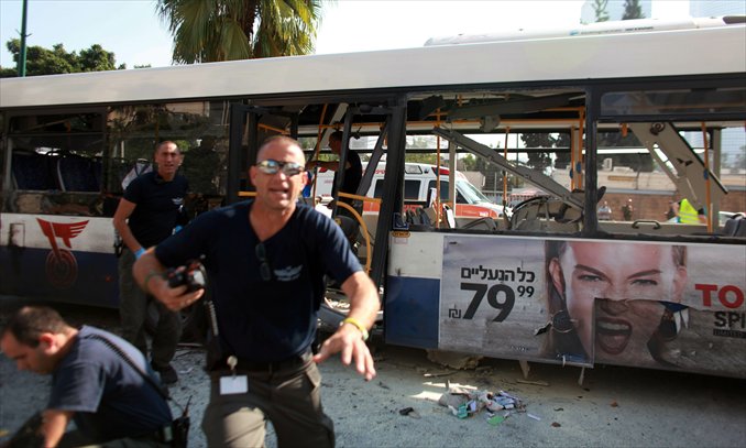 Israeli police gather after a blast ripped through a bus near the defense ministry in Tel Aviv on Wednesday. At least 21 people were injured, in what an official said was 