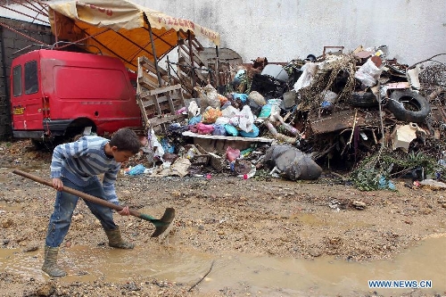 A child tries to clear the scene after the heavy rainfull in Beni Messous suburb, in upper Algiers, Algeria, on May 22, 2013. Heavy rain poured since Tuesday in several provinces in northern part of the country, claiming the life of one citizen, injuring three others, and causing extensive damages. (Xinhua/Mohamed Kadri) 