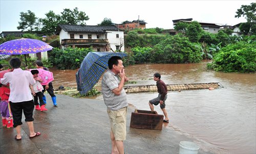 Villagers  at Meizhou, Guangdong Province see their houses drown in floods which hit the city on Sunday. The heavy rain, which brings an average 50.8 millimeter precipitation in Meizhou from Saturday morning to Sunday afternoon, has blanketed four counties and 31 villages with some 237,000 people. One died in the flood and one is missing,  as the rain led to collapsed houses, paralyzed traffic, and cut off electricity in parts of the city. Photo: CFP