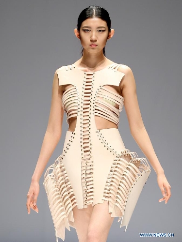 A model presents a creation designed by students from China Academy of Art during the 1st China Graduate Fashion Week in Beijing, capital of China, April 24, 2013. A total of 610 graduate students from 22 universities will present their designs during the five-day event which kicked off on Wednesday. (Xinhua/Chen Jianli)