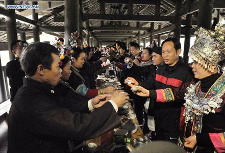 People of the Dong ethnic group attend a feast during a celebration ceremony marking the 100th anniversary of the completion of Chengyang Fengshui Bridge held in Sanjiang Dong Autonomous county, South China's Guangxi Zhuang Autonomous Region, December 1, 2012. Built in 1912, the 77.76-meter-long bridge is famed for its combination of bridge, veranda and Chinese pavilion. (Xinhua/Lai Liusheng) 

