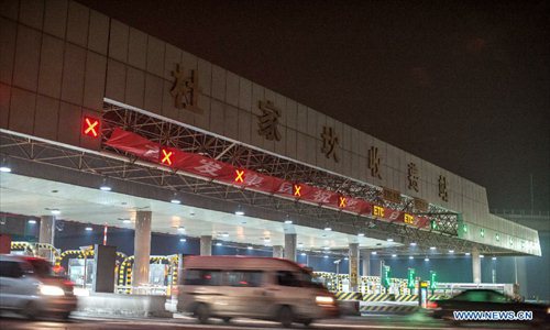 Cars move through a toll gate of highway in Beijing, capital of China, on Feb. 9, 2013. The highways in China will be toll-free for passenger cars from 0:00 on Feb. 9 to 24:00 on Feb. 15 when most Chinese will go home for the Spring Festival and return to work. Photo: Xinhua
