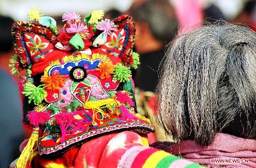 &nbsp;A grandma holds her grandchild who wears a traditional tiger hat as they head for a New Year fair in Tuocheng County, central China's Henan Province, Jan. 20, 2004. People living in the central China's region usually follow a tradition to wear new clothes and children are dressed with tiger hats or shoes to ward off eveil spirits during the Spring Festival or Chinese Lunar New Year. (Xinhua/Wang Song)
