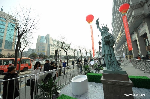 A miniature monument of the Statue of Liberty is seen on a street in Xi'an, capital of northwest China's Shaanxi Province, Jan. 10, 2013. A collection of miniatures of 10 world cultural heritages are on show here. (Xinhua/Li Yibo)  