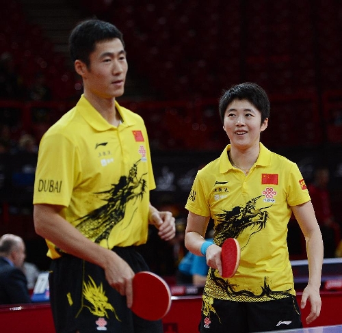Wang Liqin (L) and Rao Jingwen of China react during the first round of mixed doubles against Thavisack Phathaphone and Thiphakone Southammavong of Laos at Palais omnisport de Paris Bercy in Paris, France, on May 14, 2013. Wang and Rao won 4-0. (Xinhua/Tao Xiyi) 