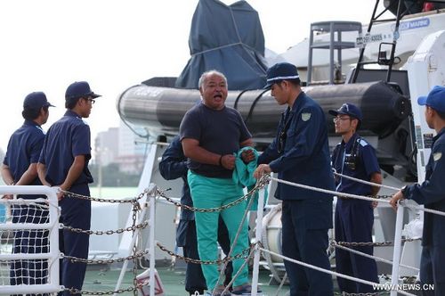 A Chinese activist (C) arrested by Japanese police after landing on Diaoyu Islands in East China Sea gets off a patrol boat of Japan Coast Guard (JCG) at Naha Port in Okinawa, Japan, Aug. 16, 2012. Japanese police arrested 14 Chinese activists on suspicion of 