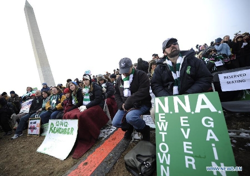 People hold signs against gun violence in front of the Washington Monument during a march in Washington D.C., capital of the United States, Jan. 26, 2013. Thousands of people, including family members of victims and survivors of shootings at Virginia Tech University, Sandy Hook elementary school and others, took part in a march for stricter gun control laws here on Saturday. (Xinhua/Zhang Jun) 
