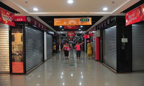 Shoppers walk through a market on Tuesday in Shenyang where shops were closed. Photo: CFP