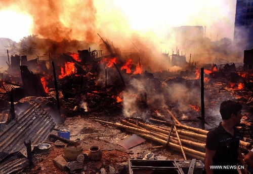 A man cries over a fire accident in a slum in Dhaka, Bangladesh, Feb. 3, 2013. About 100 shanties were destroyed in the accident, official said. (Xinhua/Shariful Islam) 