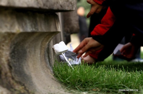 Paper flowers and paper cranes are presented to a monument at Yuhuatai Martyr Cemetery in Nanjing, capital of east China's Jiangsu Province, March 30, 2013, to pay respect to martyrs ahead of the Qingming Festival, or Tomb Sweeping Day, which falls on April 4 this year. (Xinhua/Xu Yijia)