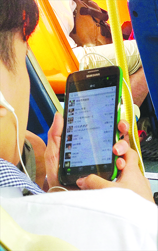 A woman uses WeChat on her smartphone while taking the bus in Guangzhou, Guangdong Province. Photo: CFP
