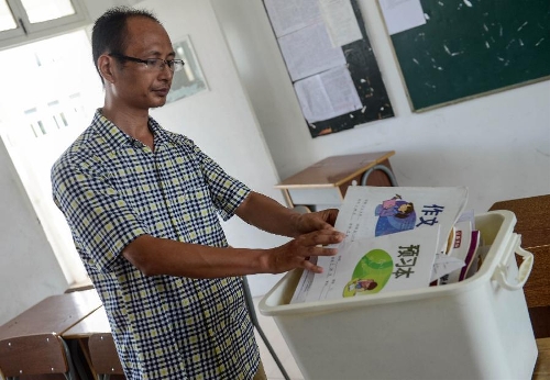 Jiang Jianming, the Chinese teacher of Wang Linjia, puts Wang's books away at Jiangshan Middle School in Jiangshan, east China's Zhejiang Province, July 8, 2013. Two Chinese passengers, Wang Linjia and Ye Mengyuan, were killed in a crash landing of an Asiana Airlines Boeing 777 at the San Francisco airport on Saturday morning. The two girls are both students of Jiangshan Middle School. Their family members headed for the United States on Monday.(Xinhua/Han Chuanhao) 